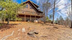 A wooden cabin with a balcony, surrounded by trees and a clear sky. - Magic’s Rest 2 Bed Cabin located in Peaceful Gated Community with lake access (Lake Lure)