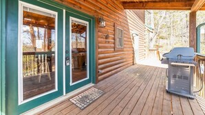A wooden cabin with a covered porch, a grill, and a door with a window. - Magic’s Rest 2 Bed Cabin located in Peaceful Gated Community with lake access (Lake Lure)