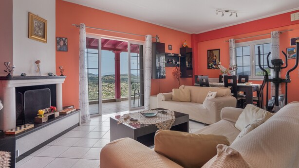 Una sala de estar con chimenea, un sofá, una mesa de centro y un comedor con mesa y sillas.