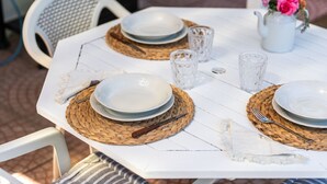Un tavolo apparecchiato con piatti, posate e un vaso di fiori.