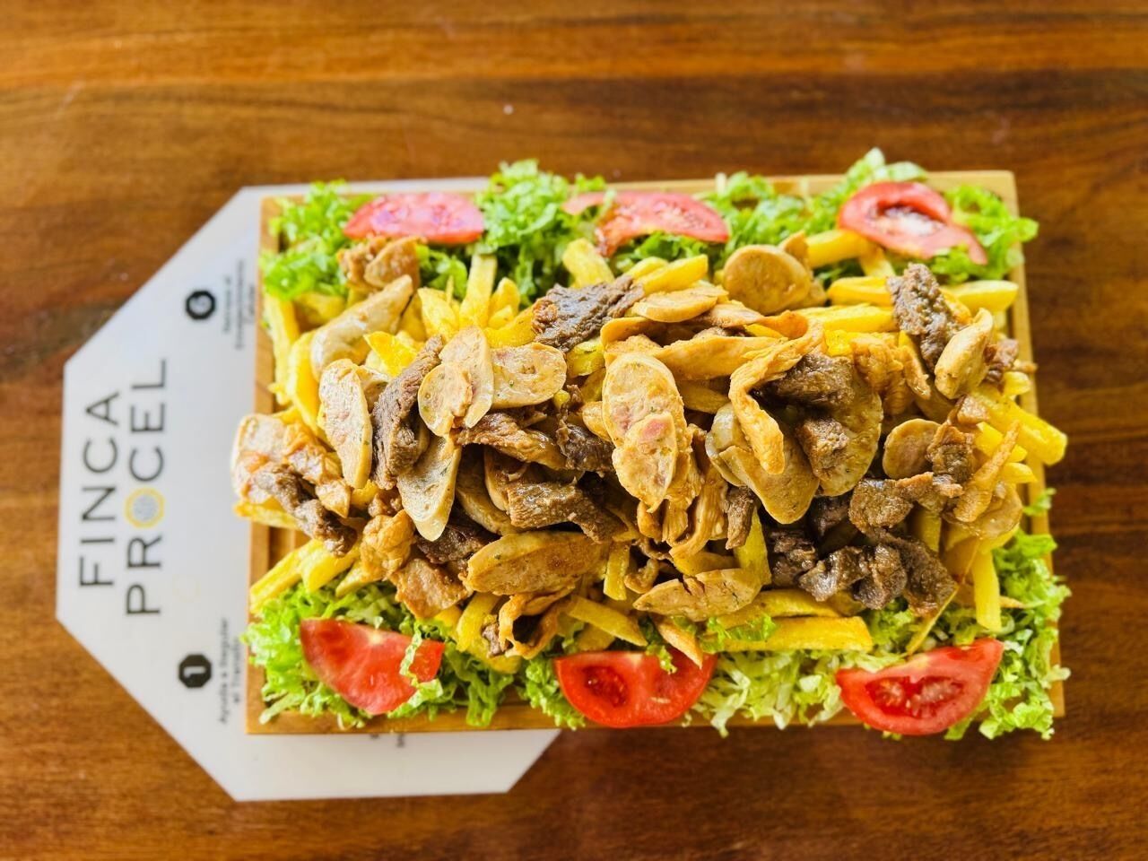 A sandwich with lettuce, tomato, and meat on a wooden surface.