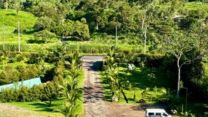 A rural road leading to a white building with a covered entrance. - HOTEL FINCA PROCEL (Palora)