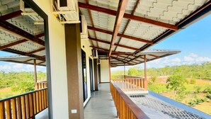 A covered corridor with a wooden railing, air conditioning units, and a view of the landscape. - HOTEL FINCA PROCEL (Palora)
