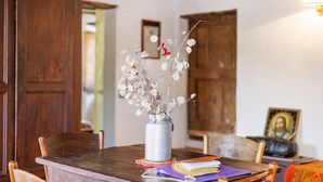Ein Holztisch mit einer Vase getrockneter Blumen, einem Buch und einem gerahmten Bild darauf.