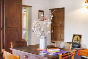 A wooden dining table with a vase of dried flowers, a book, and a framed picture on it. - Holiday Home 'Ca' Rionda' with Mountain View, Private Garden and Wi-Fi (Osiglia)