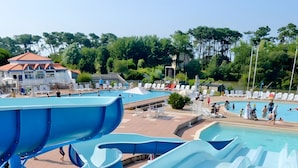 A water park with multiple slides, a pool, and a building with a red roof. - Apartment 'La Terrasse Du Golf' with Shared Pool, Private Terrace and Balcony (Talmont-Saint-Hilaire)