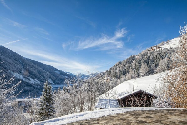 A mountainous landscape with a snow-covered building and trees.