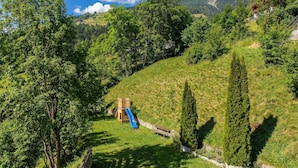 A playground with a slide and climbing structure, surrounded by trees and a hill. - Gasthof Kirchsteiger 'Zimmer 5' with Lake View, Shared Terrace and Wi-Fi (Santa Valburga)
