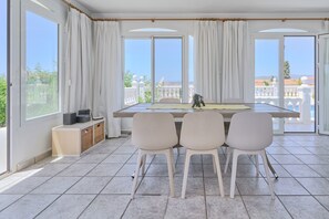 Un espace repas comprenant une table, des chaises et une vue sur l’extérieur.