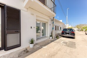 Ein modernes, zweistöckiges Gebäude mit Garage, Balkon und blauem Himmel.
