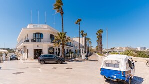 A hotel with a white facade, a balcony, and a parked car. - Holiday Home 'Idrusa A Otranto' with Balcony, Wi-Fi and Air Conditioning (Otranto)