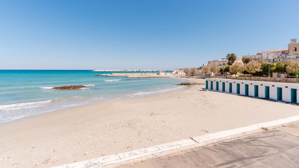 A beach with a clear sky, a sandy shore, and buildings in the background. - Holiday Home 'Idrusa A Otranto' with Balcony, Wi-Fi and Air Conditioning (Otranto)