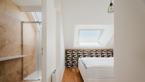 Une chambre avec un puits de lumière, une douche et un mur orné d’un motif.