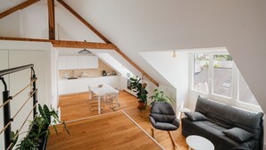 Une pièce de style loft comprenant un coin repas, un canapé et de grandes fenêtres.