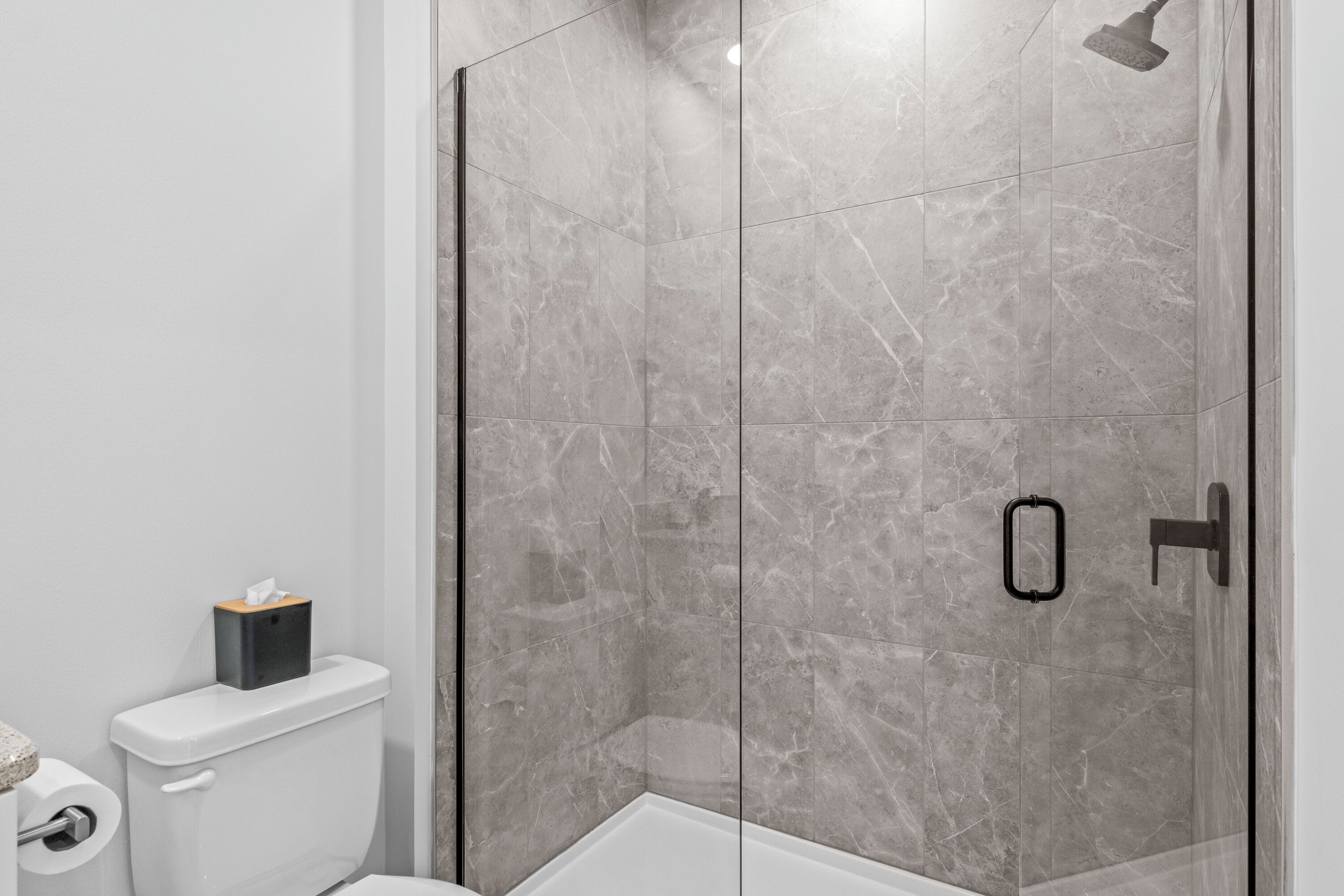 Een moderne badkamer met een douchecabine, een toilet en een douchetoilet.