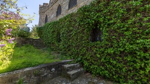 A stone building with arched windows, a stone staircase, and lush greenery. - Castle 'Isla Del Burguillo' with Private Terrace, Private Garden and Wi-Fi (Avila)