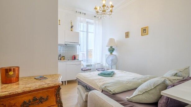 Un dormitorio con cama, escritorio, silla, lámpara y candelabro.