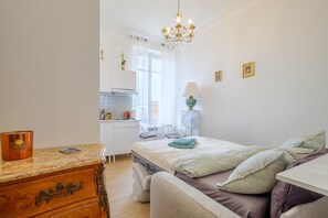 Une chambre à coucher comprenant un lit, un bureau, une chaise, une lampe et un lustre.