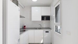 A compact kitchen with white cabinetry, a built-in microwave, and a dishwasher. - Country House 'Valle Conil' with Private Pool, Wi-Fi and Air Conditioning (Conil de la Frontera)