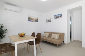 A modern living room with a dining table, chairs, a sofa, and wall art. - Country House 'Valle Conil' with Private Pool, Wi-Fi and Air Conditioning (Conil de la Frontera)