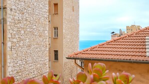 A stone building with a tiled roof, a view of the sea, and a satellite dish. - Apartment 'Jolie Proche Monaco' with Wi-Fi (Beausoleil)