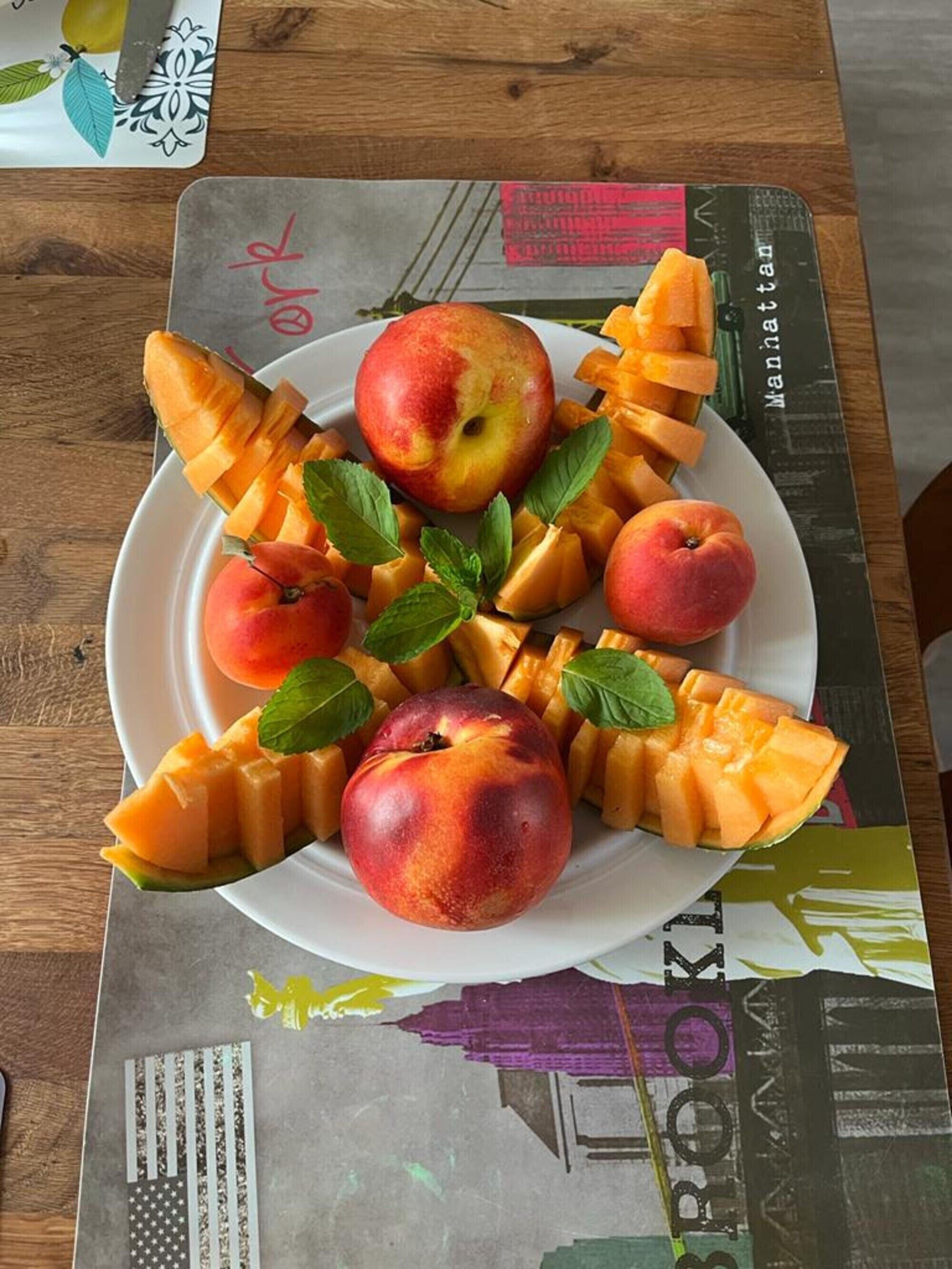 Un plato de fruta sobre una mesa con posavasos.