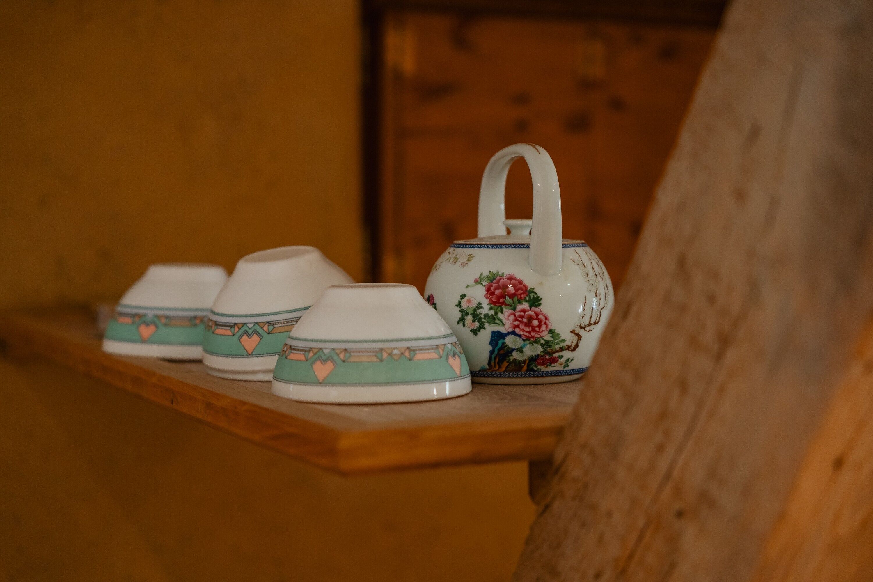 Une étagère en bois avec des théières et des tasses en céramique.