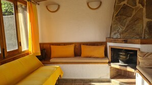 A room with a sofa, a fireplace, and a stone wall. - Rural House 'El Valle' in Sierra de Gredos, Pool and Scenic Views (Piedralaves)