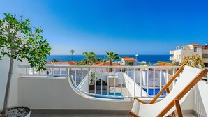 A balcony with a pool, a chair, and a view of the sea and buildings. - Vacation Home 'La Perla' with Sea View, Wi-Fi and Air Conditioning (Callao Salvaje)