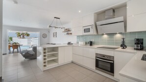 A modern kitchen with white cabinetry, a built-in oven, a microwave, and a coffee maker. - Vacation Home 'La Perla' with Sea View, Wi-Fi and Air Conditioning (Callao Salvaje)