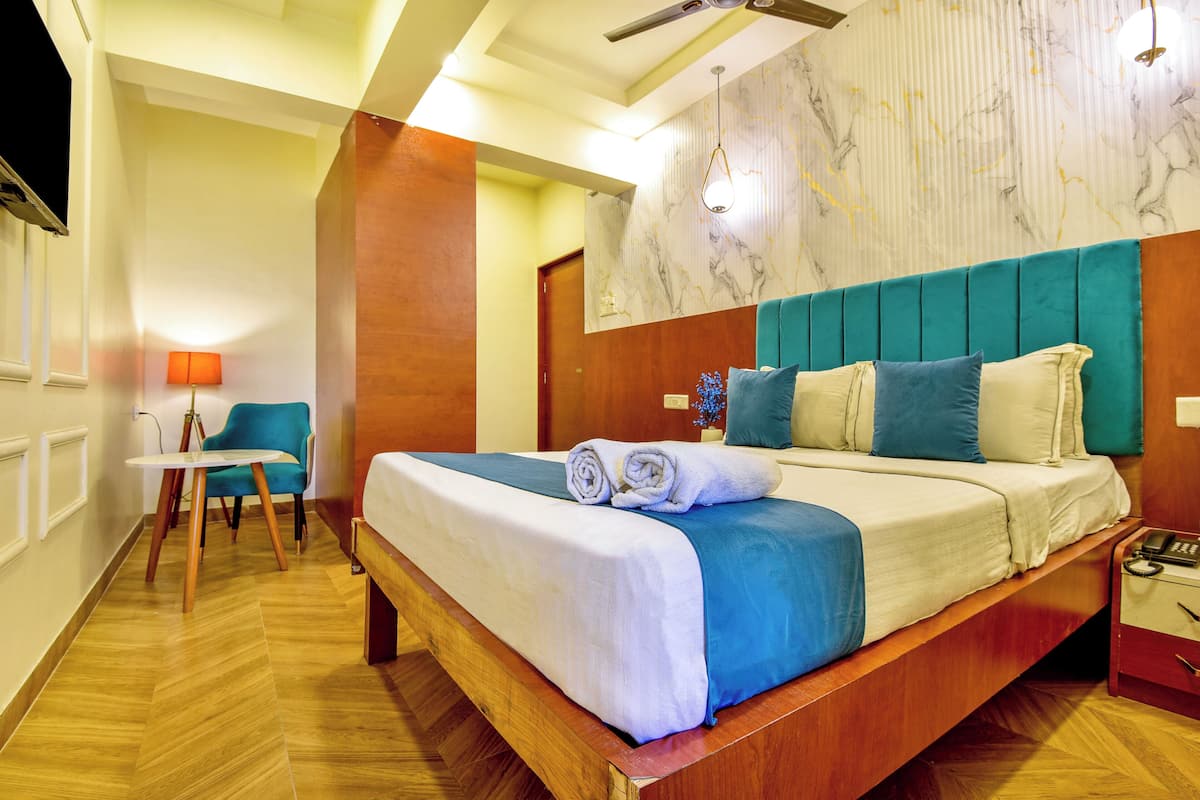 A hotel room with a wooden bed, a blue headboard, and a marble-patterned wall.