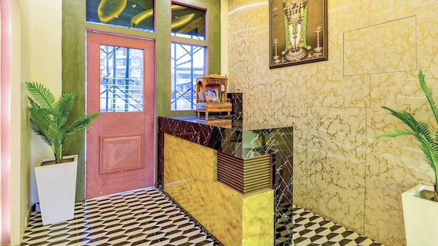 A lobby with a checkered floor, a reception desk, and a large framed artwork on the wall. - THE Solitaire Residency  (Kalyan)