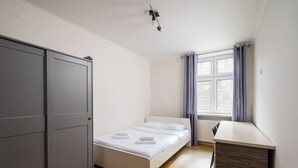 Un dormitorio con cama, escritorio y armario.
