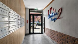 En modern hotellobby med en receptionsdisk, en väggmonterad brevlåda och en skylt som visar hotellets namn.