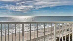 A beach view from a balcony with a railing, ocean, and a boat in the distance. - Newly Renovated 1 Bedroom Beach Condo at SeaWatch Resort Myrtle Beach (Myrtle Beach)