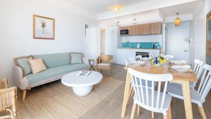 Un salon moderne avec un canapé, une table basse et un coin repas.