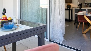 A modern kitchen with a dining area, featuring a table set for two, a fruit bowl, and a vase. - Terra Tosca by Interhome (Fréjus)