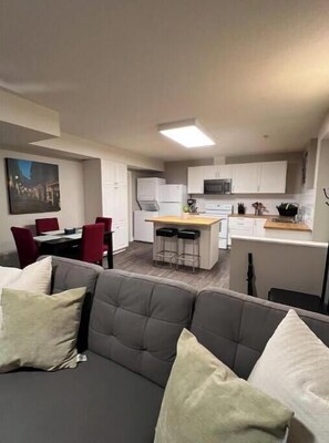 Cozy living space with a central kitchen, dining area, and comfortable seating.