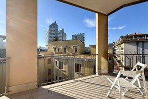 Un balcon offrant une vue sur le paysage urbain, notamment sur les gratte-ciel.