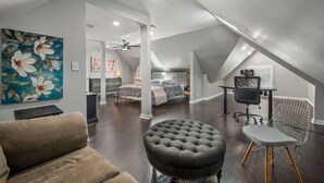 A spacious loft bedroom with a large bed, a desk, and a chair. - Flexible Relocation Stay: Spacious, Pet-Friendly, w/ Utilities near Mid/Downtown (Atlanta)