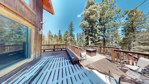 A wooden deck with a bench and chairs, overlooking a forested area. - Large Deck | Fireplace | Forest Views | Kings Landing (Angel Fire)