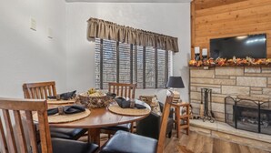 Un coin repas avec une table ronde, des chaises et une cheminée.