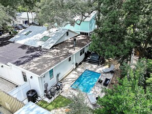 Ein Wohnhaus mit Pool, einer überdachten Terrasse und einer separaten Garage.
