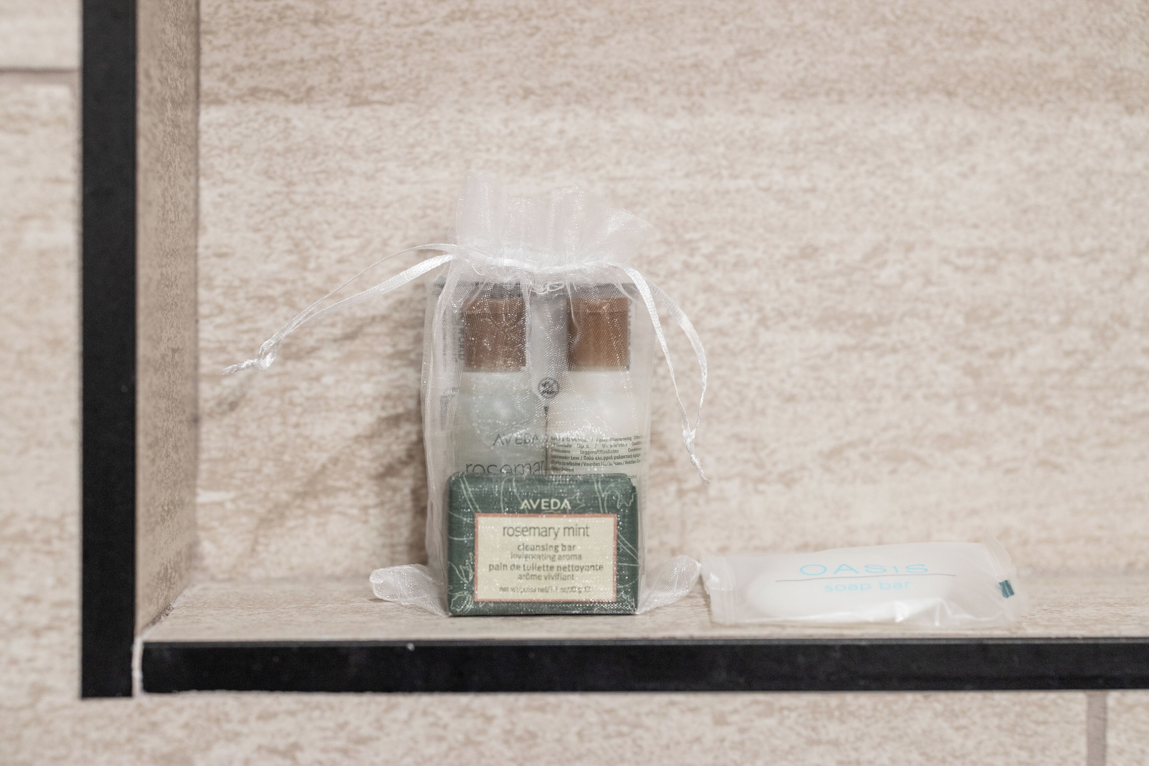 A bathroom shelf with a packaged cleansing bar and a bar of soap.