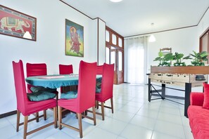 A dining area with a table, chairs, and a foosball table.