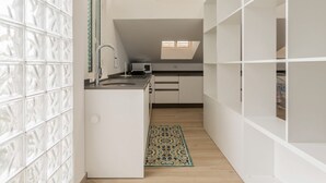 Eine moderne Küche mit weißen Schränken, einem eingebauten Herd und einem Fenster über der Spüle.