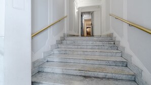 Una scalinata in marmo con balaustre dorate che conduce a una porta in cima.