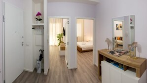 Un dormitorio moderno con cama, mesita de noche y espejo.