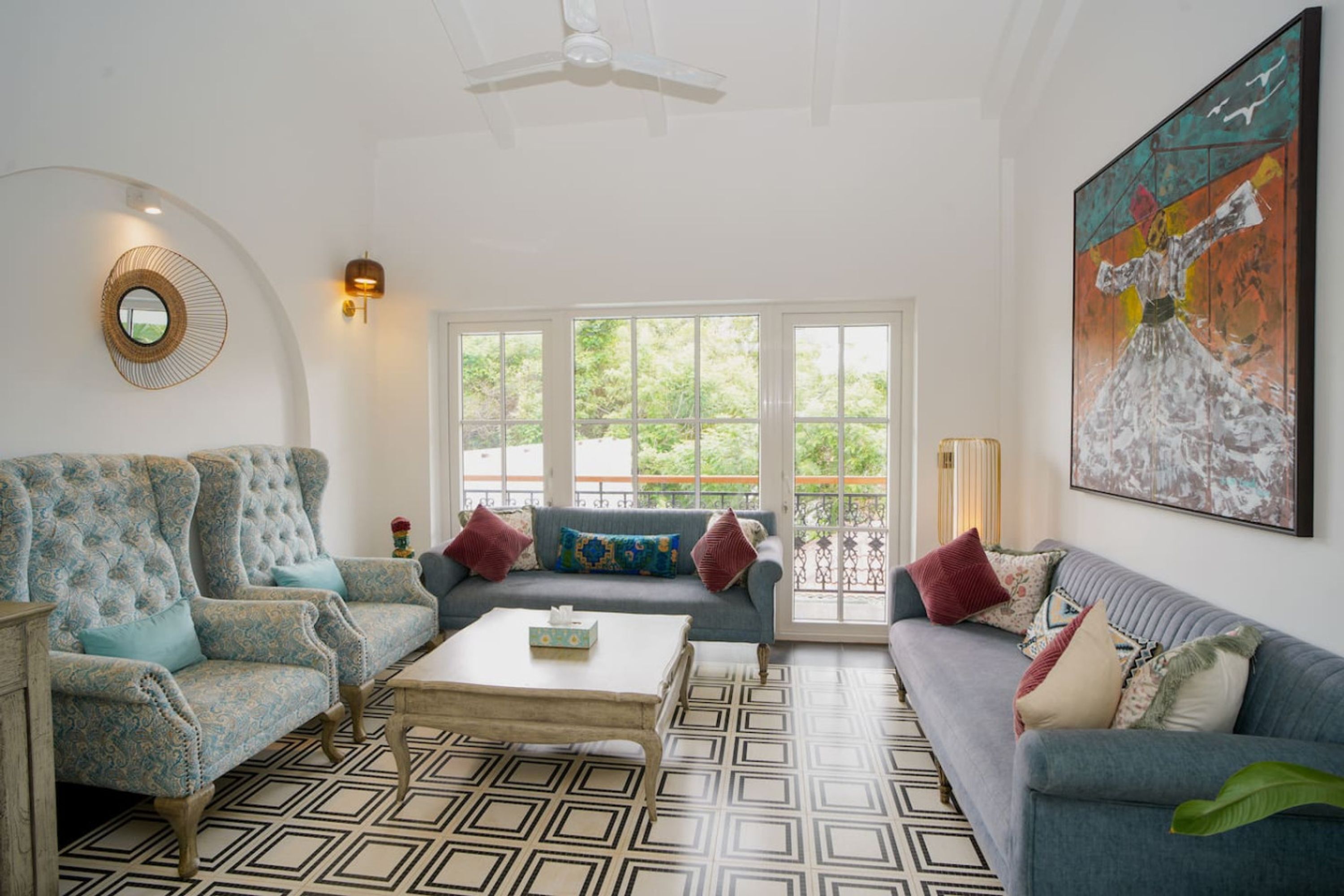 A living room with two sofas, a coffee table, and a large window with a view of greenery.