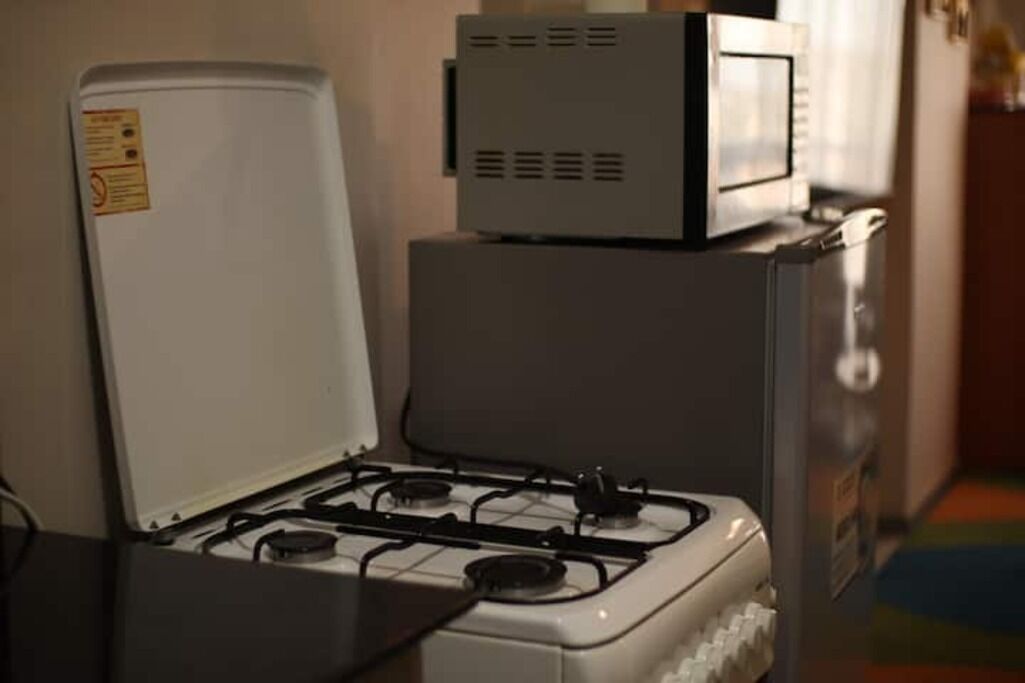 Una cocina equipada con estufa, microondas y refrigerador.